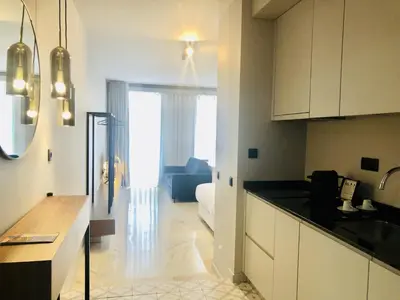 a kitchen with white cabinets and a living room at Bright and Spacious apartment in Porto in Porto