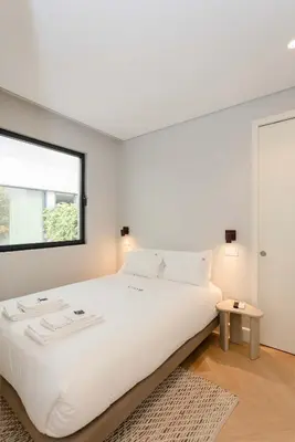 a white bedroom with a large bed and a window at Liiiving in Porto - Pool Paradise Apartments in Porto