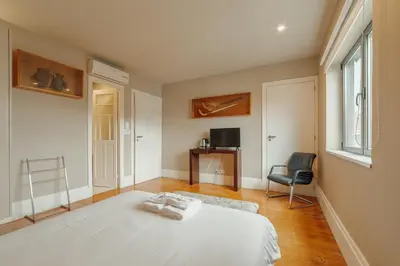 a bedroom with a bed and a chair and a window at Boutique Suites by Hosty in Porto