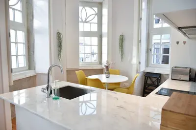 a kitchen with a sink and a table with yellow chairs at Central and comfortable apartment -downtown in Porto