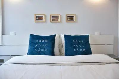a bed with two blue pillows saying take your time at Central and comfortable apartment -downtown in Porto