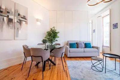 a living room with a table and chairs and a couch at Bright Flat few steps to Aliados Av by LovelyStay in Porto