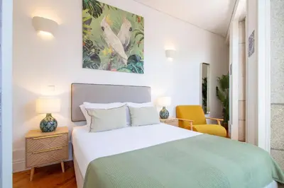 a bedroom with a bed and a painting on the wall at Bright Flat few steps to Aliados Av by LovelyStay in Porto