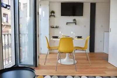 a dining room with a table and yellow chairs at Central with balcony - 9 min-walk to Trindade in Porto