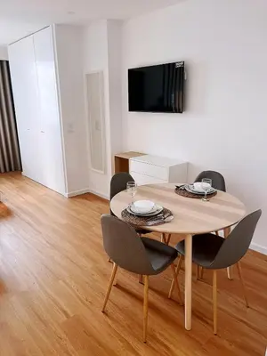 a dining room table with chairs and a flat screen tv at Downtown Studio 80 meters to metro and Free Parking in Porto