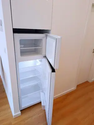 an empty refrigerator with its door open in a room at Downtown Studio 80 meters to metro and Free Parking in Porto