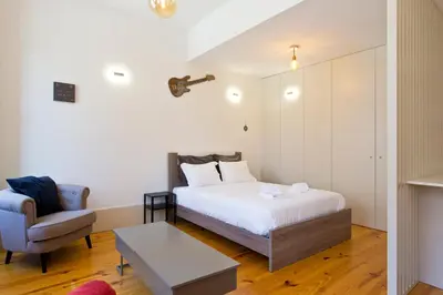 a small bedroom with a bed and a chair at Aposentus - Premium Central Apartment 1BR in Porto