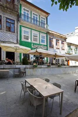a table and chairs in front of a building at Aposentus - Premium Central Apartment 1BR in Porto