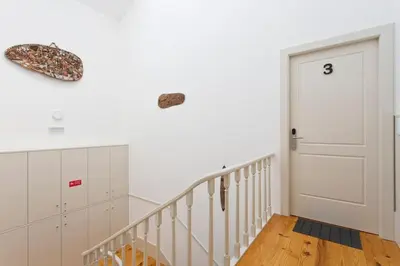 a white hallway with a staircase and a door at Aposentus - Premium Central Apartment 3BR in Porto