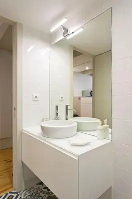 a white bathroom with a sink and a mirror at Aposentus - Premium Central Apartment 3BR in Porto