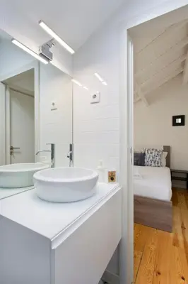 a white bathroom with a sink and a bed at Aposentus - Premium Central Apartment 3BR in Porto