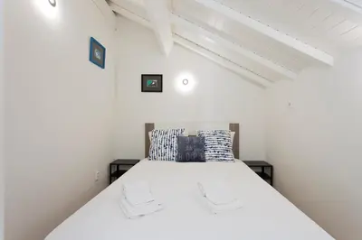 a white bed in a room with a white ceiling at Aposentus - Premium Central Apartment 3BR in Porto