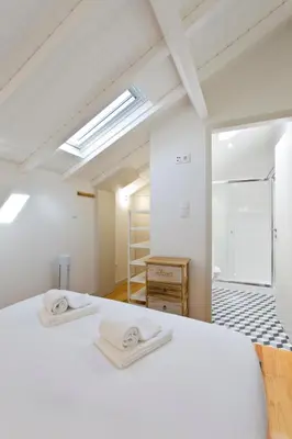 a bedroom with a white bed and a skylight at Aposentus - Premium Central Apartment 3BR in Porto