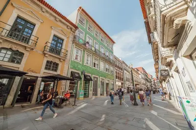 a group of people walking down a street with buildings at Flores Premium by Hosty in Porto