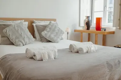 a large white bed with four pillows on it at Flores Premium by Hosty in Porto