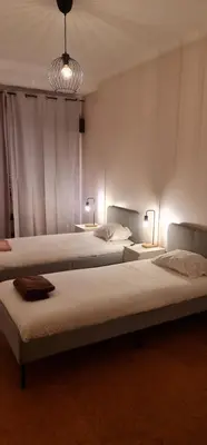 a bedroom with two beds and two tables with lights at Catarina 711 in Porto