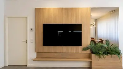 a flat screen tv on a wooden wall at Bright 2BR Flat near Praça da Galiza by LovelyStay in Porto