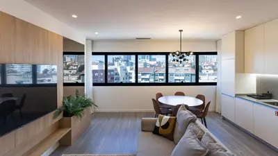 a kitchen and living room with a table and chairs at Bright 2BR Flat near Praça da Galiza by LovelyStay in Porto