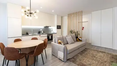 a living room and kitchen with a table and a couch at Bright 2BR Flat near Praça da Galiza by LovelyStay in Porto