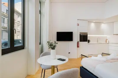 a room with a bed and a table and a kitchen at Modern Studio in Porto Center, Ideal City Base in Porto