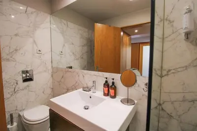 a bathroom with a white sink and a shower at Refúgio Douro à Vista in Porto