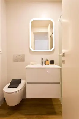 a bathroom with a white toilet and a mirror at Gabi's House in Porto