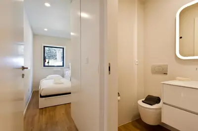 a small bathroom with a bed and a toilet at Gabi's House in Porto