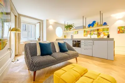 a living room with a couch and a kitchen at Discovery Luxury Historic House At Rua das Flores in Porto