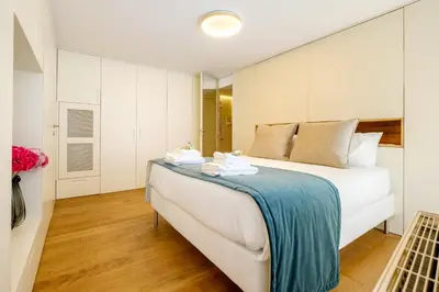 a bedroom with a large bed with white cabinets at Discovery Luxury Historic House At Rua das Flores in Porto
