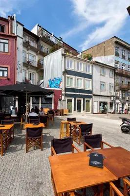 an outdoor patio with tables and chairs and buildings at Aposentus - Poveiros Terrace View in Porto