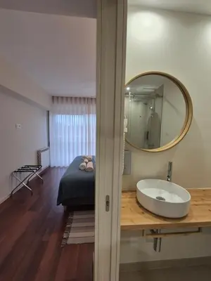 a bathroom with a sink and a mirror and a bed at Sleep Swell in Porto