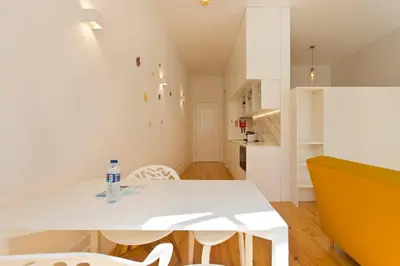 a white dining room with a white table and chairs at APOSENTUS - Your home in Almada in Porto