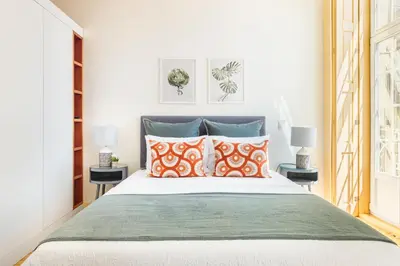 a bedroom with a bed with orange and green pillows at São Miguel Apartments in Porto