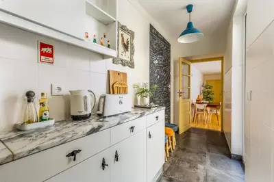 a kitchen with white cabinets and a counter top at São Miguel Apartments in Porto