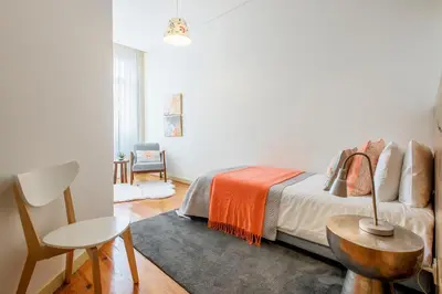 a bedroom with a bed and a table and a chair at São Miguel Apartments in Porto