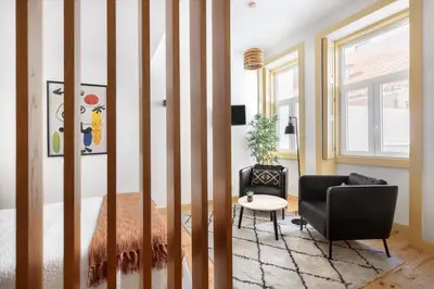 a room with a bed and a chair and a table at São Miguel Apartments in Porto
