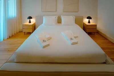 a bedroom with a large white bed with towels on it at The Cale - Porto, Firmeza 1 in Porto