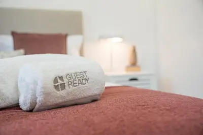 a pillow with a guest feed written on it on a bed at GuestReady - Urkunina apartment in Porto