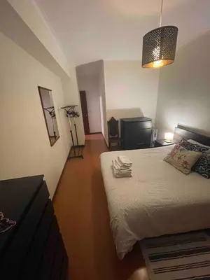 a bedroom with a bed and a desk and a lamp at T1 near El Corte Inglés in Vila Nova de Gaia