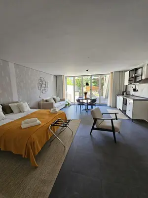 a bedroom with a large bed and a living room at Lima Junior Residences in Porto