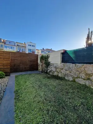 a backyard with a stone wall and a fence at Lima Junior Residences in Porto