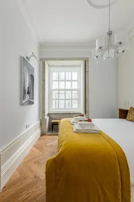 a bedroom with a bed with a yellow blanket on it at Bailarina Historic Luxury House at Rua das Flores in Porto