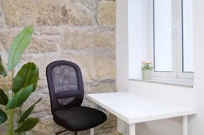 a black chair sitting next to a white desk at Sunny House with Patio, Walk to Attractions in Vila Nova de Gaia