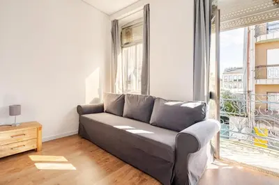 a living room with a couch and a large window at 2-Studio House Steps from Best Attractions of Porto in Vila Nova de Gaia