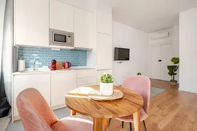 a kitchen and dining room with a wooden table and chairs at 2-Studio House Steps from Best Attractions of Porto in Vila Nova de Gaia