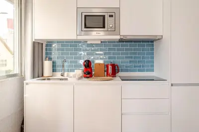 a kitchen with white cabinets and a microwave at 2-Studio House Steps from Best Attractions of Porto in Vila Nova de Gaia