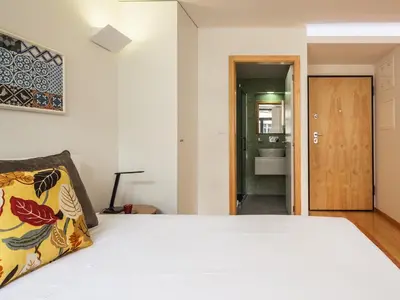 a bedroom with a white bed and a bathroom at Trindade by Guestify in Porto