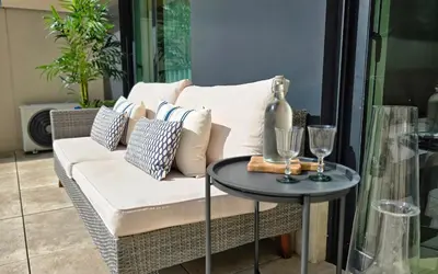 a white couch with pillows and a table with wine glasses at Central Apartment with parking/terrace in Porto