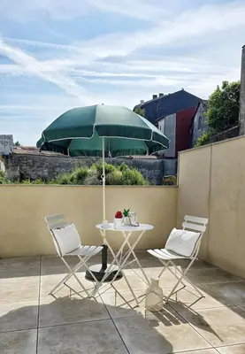a table and two chairs and a green umbrella at Central Apartment with parking/terrace in Porto