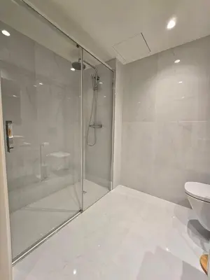 a white bathroom with a shower and a toilet at Central Apartment with parking/terrace in Porto